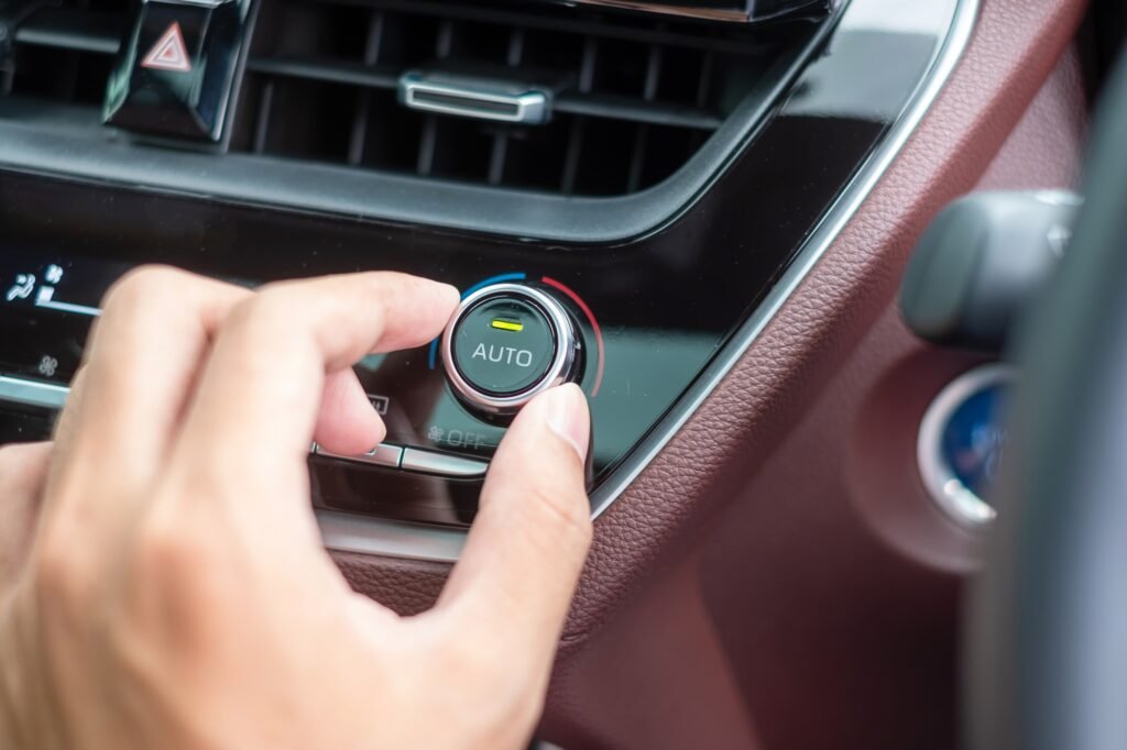 man hand adjusting temperature the air flowing during driving car on the road, air conditioner cooli